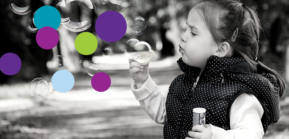 Child blowing bubble with colors